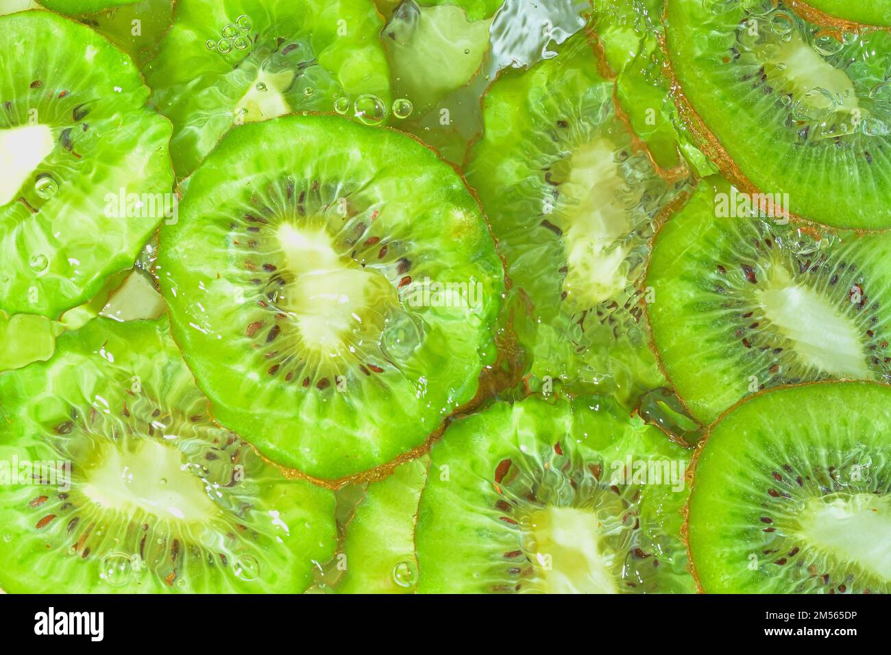 Primo piano fette fresche di kiwi su fondo bianco. Fette di kiwi in acqua frizzante su fondo bianco, primo piano. Immagine orizzontale. In alto Foto Stock
