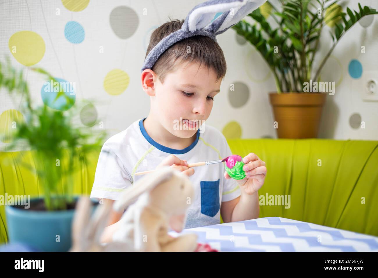 Buona Pasqua. Ragazzo in orecchie coniglietto tintura uovo colorato per la caccia di Pasqua Foto Stock