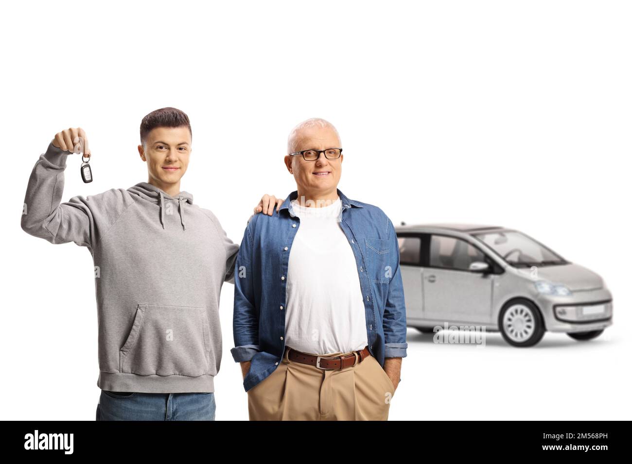 Felice padre e figlio mostrando una chiave e in piedi di fronte a una macchina d'argento isolato su sfondo bianco Foto Stock