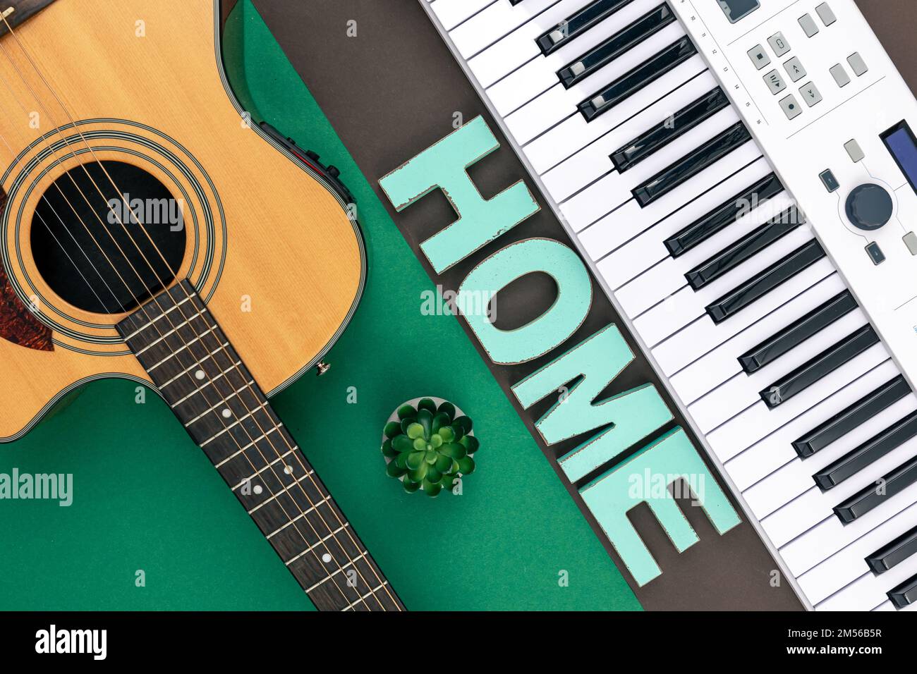 Tasti musicali, chitarra e parola decorativa a casa su uno sfondo colorato. Foto Stock