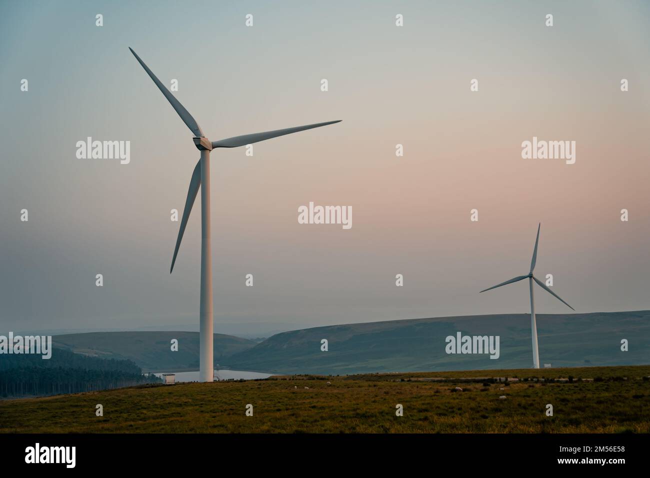 Turbine eoliche, mulini a vento al tramonto. Concetto di fonte di energia rinnovabile sostenibile. Fattoria eolica nel Galles del Sud, Regno Unito. Foto Stock