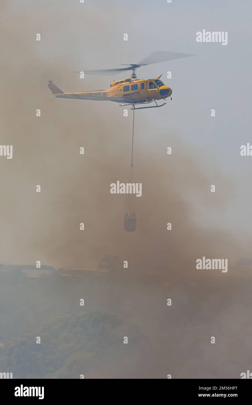 Un colpo verticale di un elicottero antincendio spegne un incendio Foto Stock