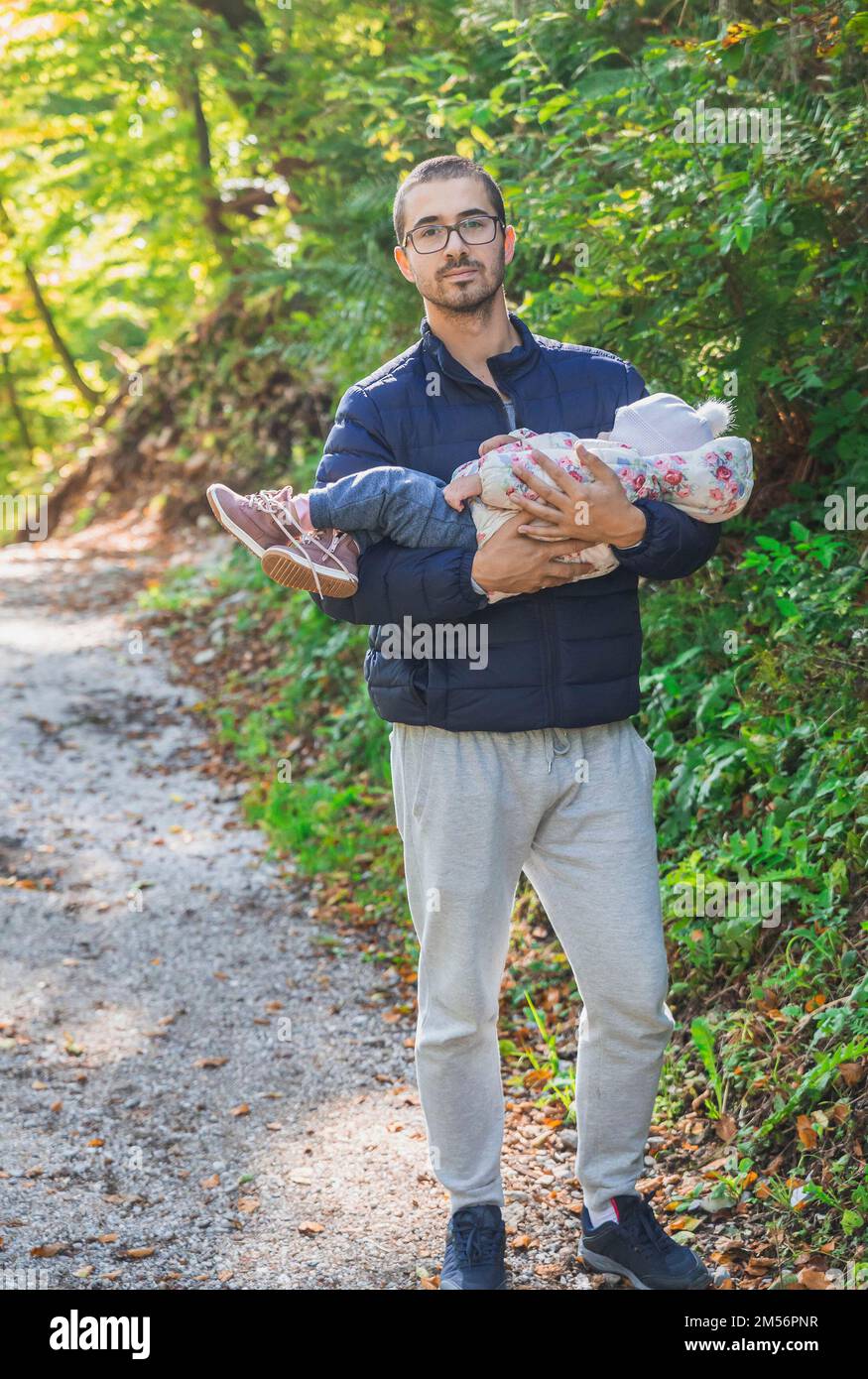 Padre che tiene un bambino addormentato nel parco Foto Stock