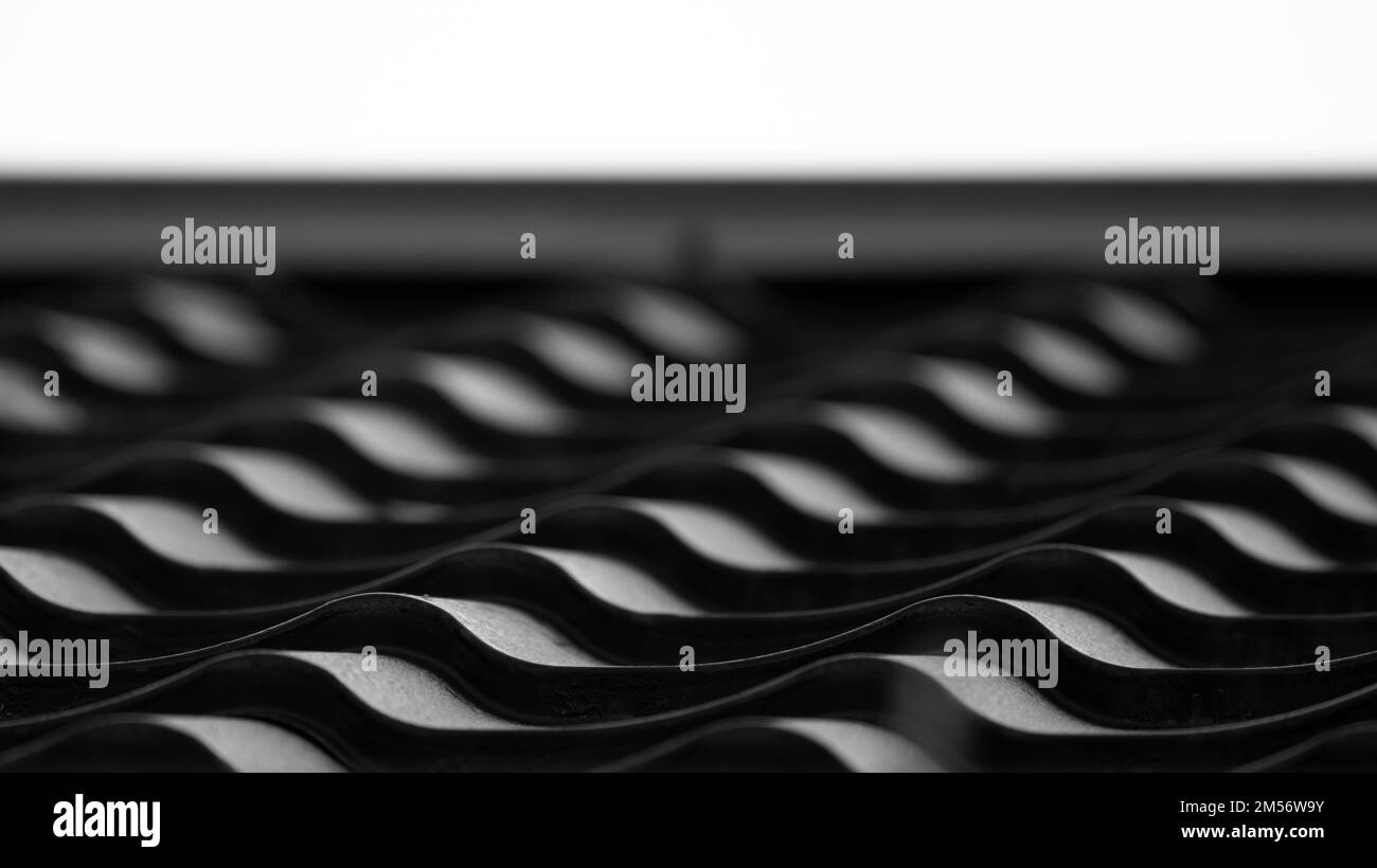 Tegole in metallo nero con motivo a forma ondulata, primo piano foto in bianco e nero del moderno tetto della casa di campagna Foto Stock