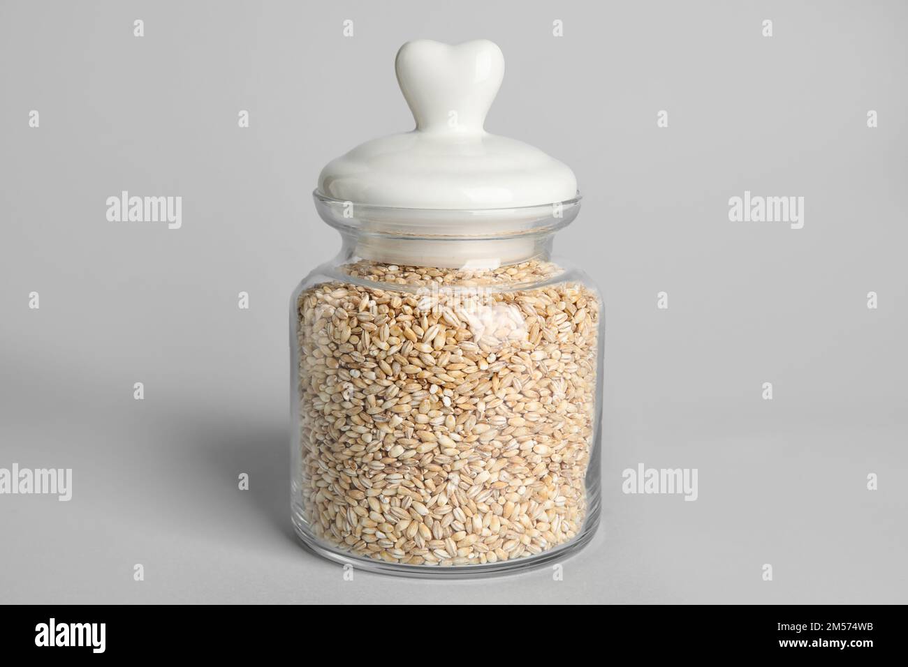 Vaso di vetro di orzo perlato su sfondo bianco Foto Stock