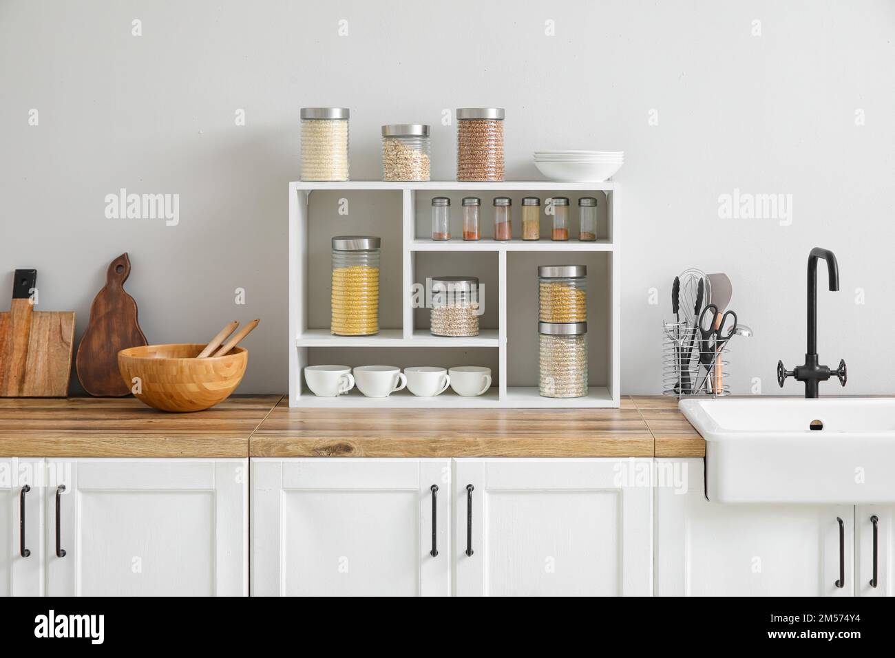 Vasetti con cereali, spezie e utensili da cucina Foto Stock