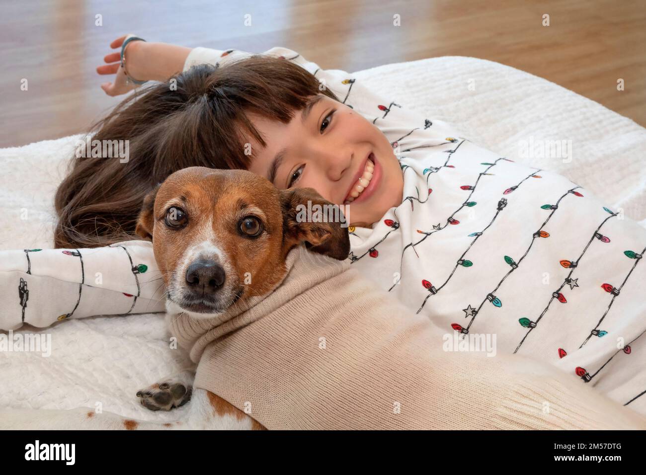 Una ragazza di 10 anni e il suo cane animale domestico che posa accogliente sul  letto Foto stock - Alamy