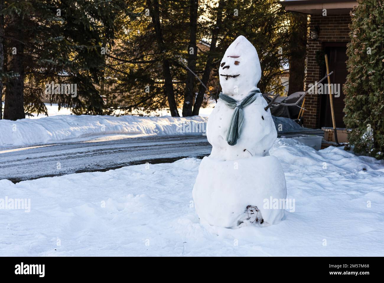Pupazzo di neve naturale con una sciarpa in strada della città nordamericana Foto Stock