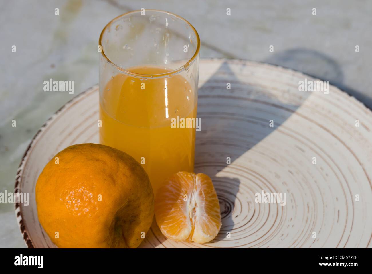 succo di frutta di clementina o mandarino o d'arancia con una fetta o un segmento di esso conservato su un piatto. frutta popolare di stagione di inverno in india. buona fonte di vita Foto Stock