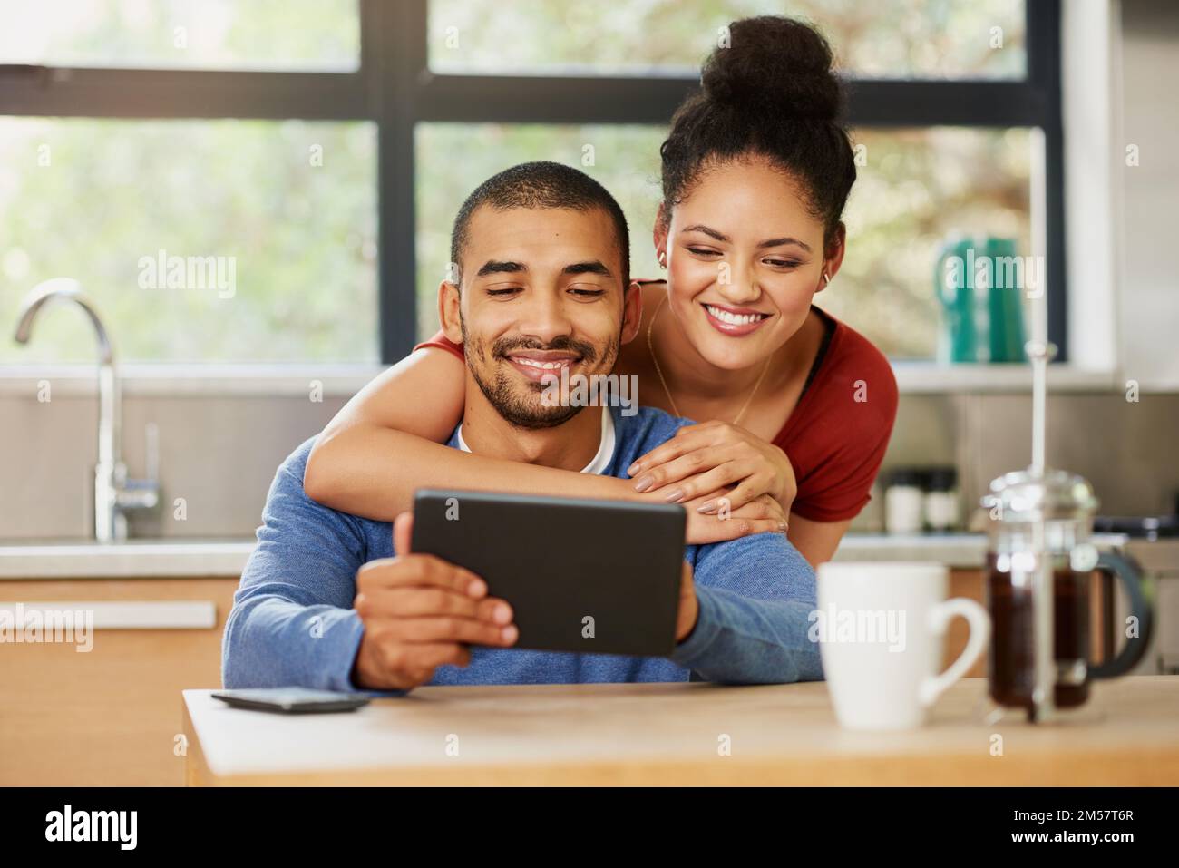 Intrattenimento per i Millennial accoppiati. una giovane coppia felice che usa un tablet digitale insieme a casa. Foto Stock