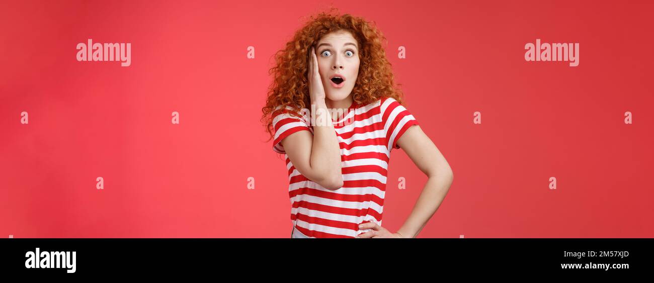 Shocked Amused emotive redhead zenzero ragazza ricci capelli chiazzare occhi fotocamera affascinato bocca aperta gasping divertito react Foto Stock