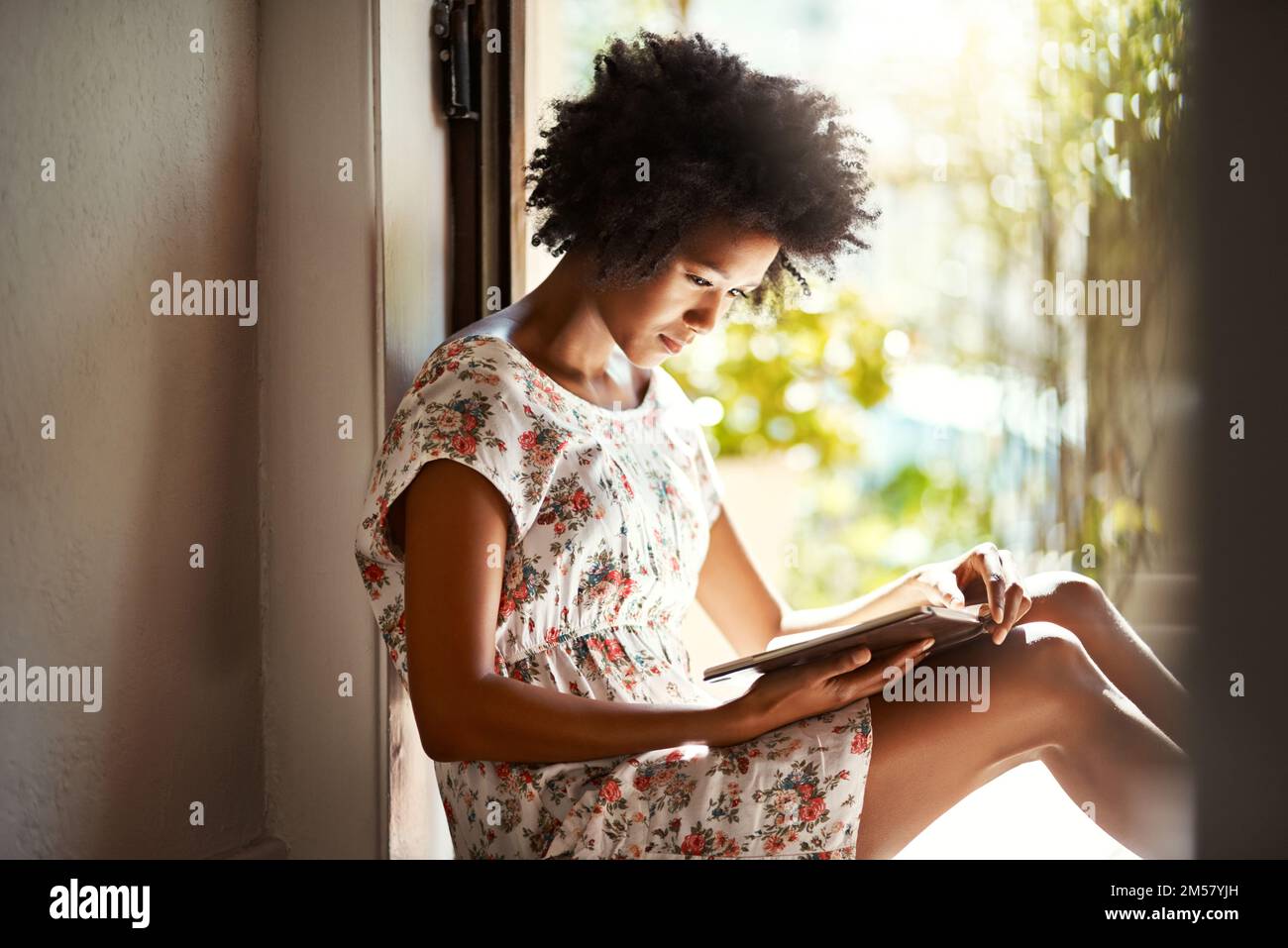 In profondità tra le pagine di un buon libro. una giovane donna che si rilassa con un libro a casa. Foto Stock