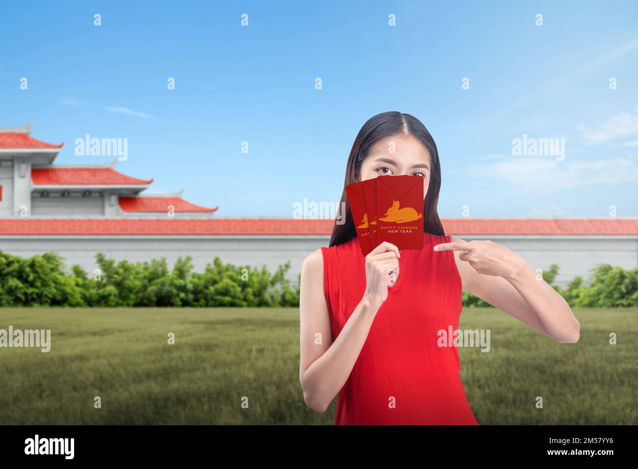 Donna cinese asiatica in un abito cheongsam tenendo buste rosse con un  simbolo di coniglio. Felice anno nuovo cinese. Capodanno cinese del  coniglio Foto stock - Alamy