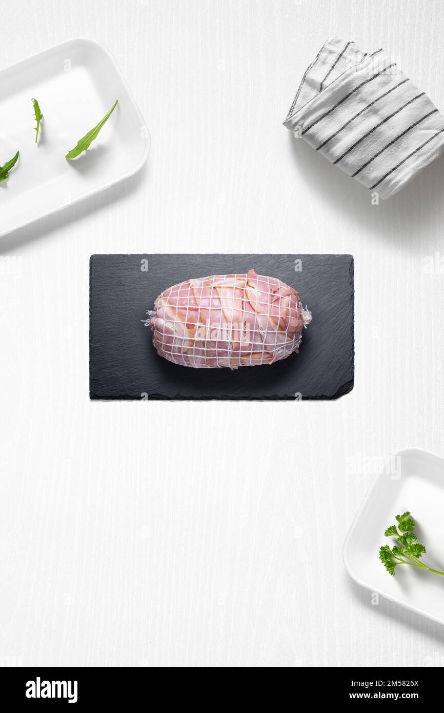 Roti di manzo con pancetta in cucina con alcune erbe dall'alto Foto Stock