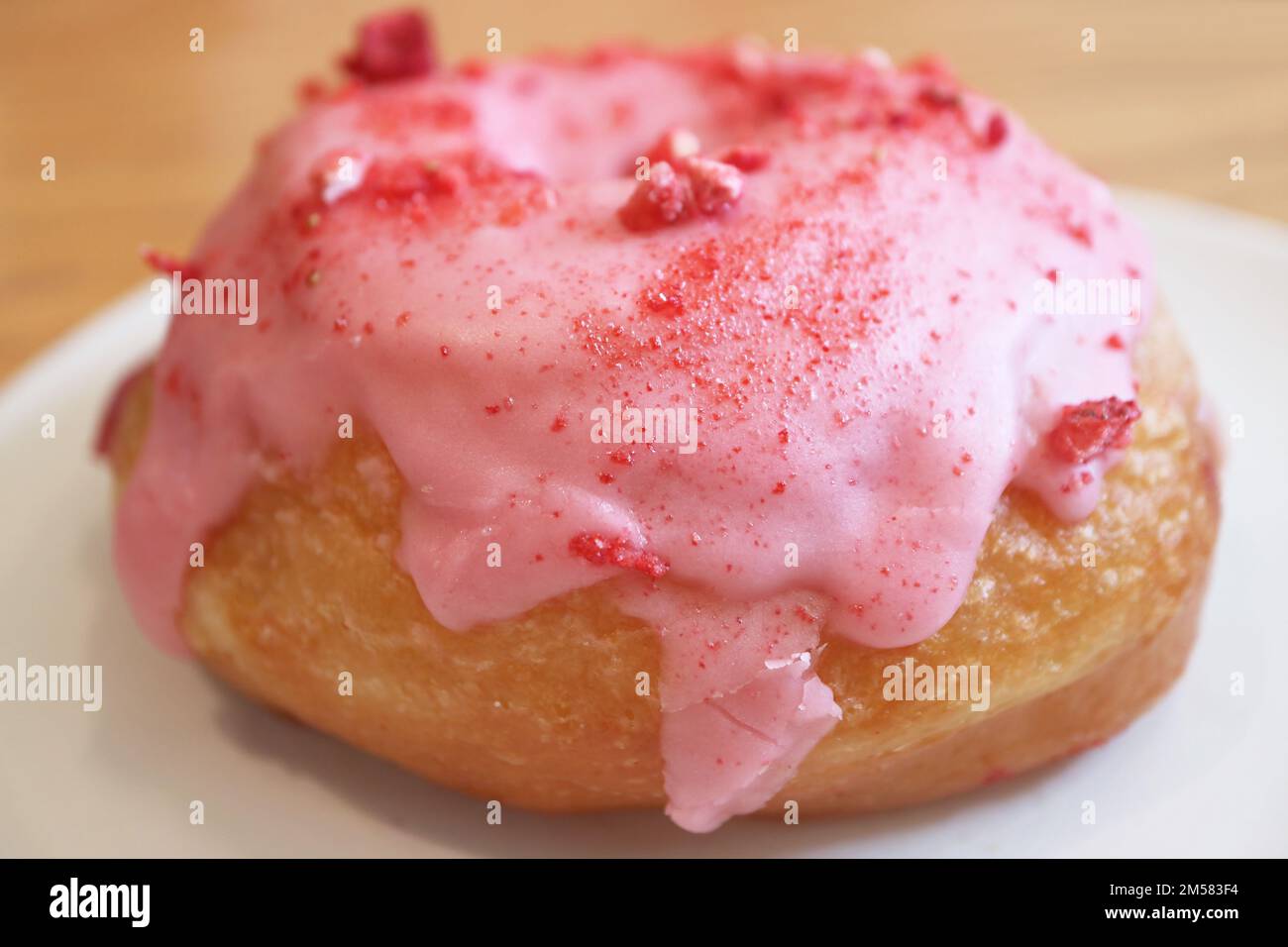 Closeup di fragola-glassato appetitoso con crema di lamponi ripieno ciambella Foto Stock