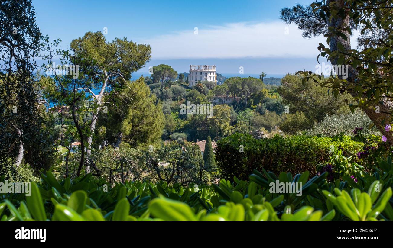 Saint-Jean-Cap-Ferrat - 3 maggio 2022: Una villa vista in lontananza dal giardino della Villa Ephrussi de Rothschild. Preso in un giorno di primavera soleggiato wit Foto Stock