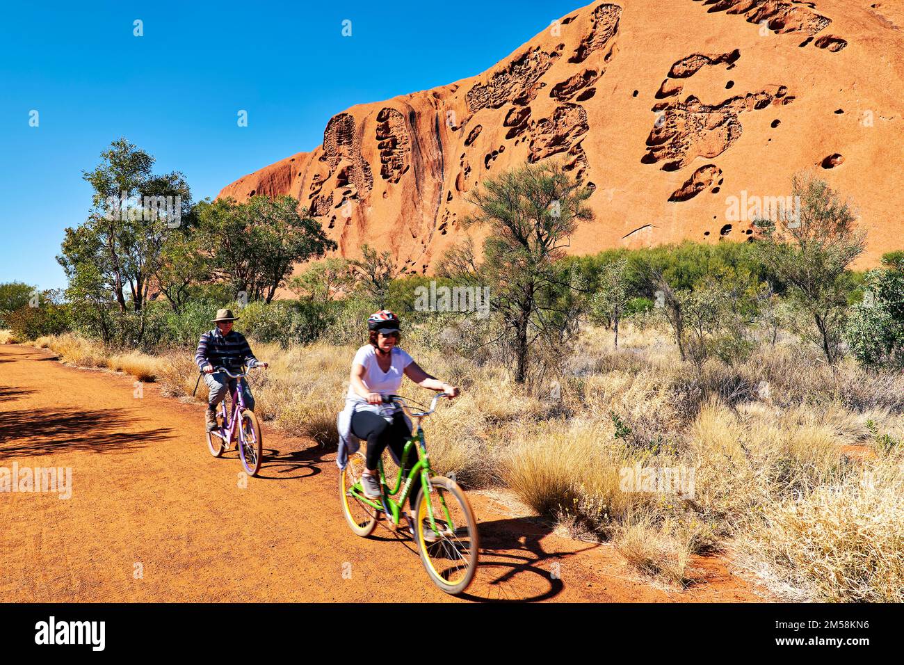 A cavallo di una bicicletta intorno Uluru Ayers Rock. Territorio del Nord. Australia Foto Stock