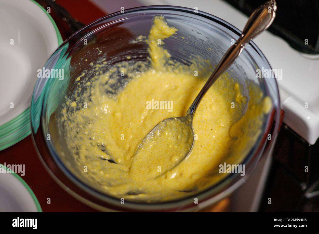 ciotola di pastella di cornbread normale che è cucchiaiata nelle carte di cupcake Foto Stock