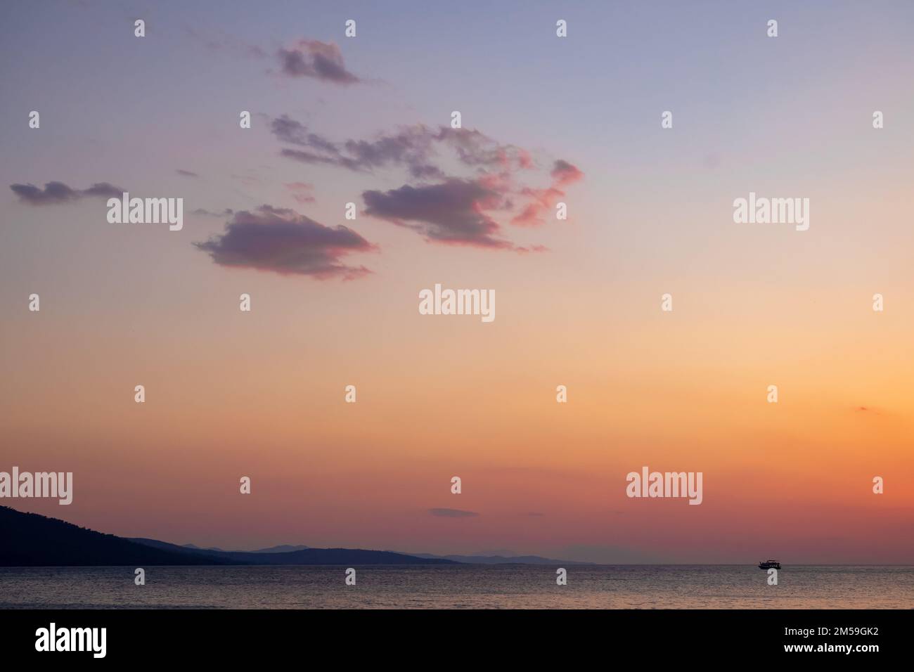 le nuvole appaiono quando il cielo cambia da blu a rosso al tramonto Foto Stock
