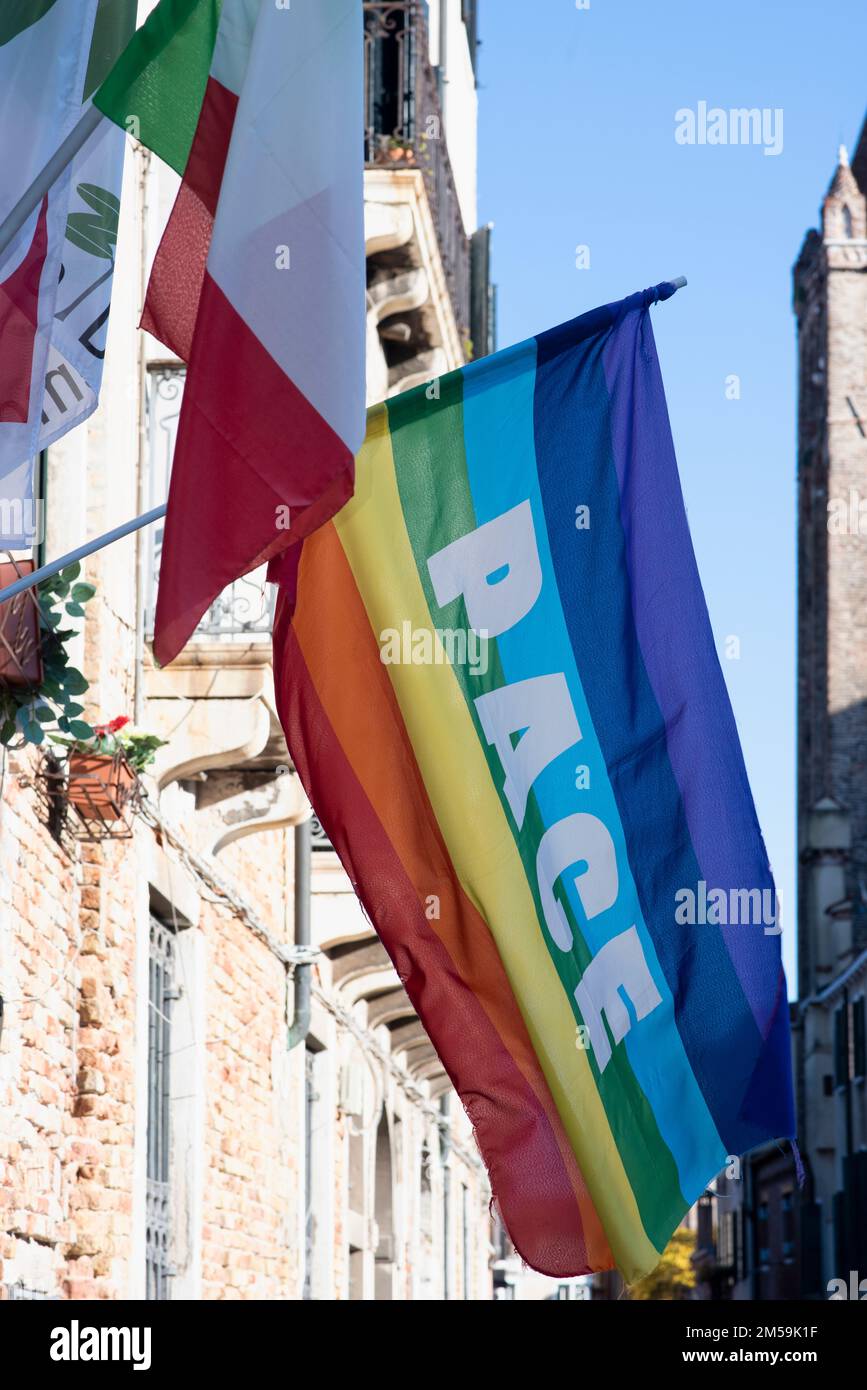 Bandiera colorata con testo di pace in italiano appeso in una finestra a Venezia Foto Stock