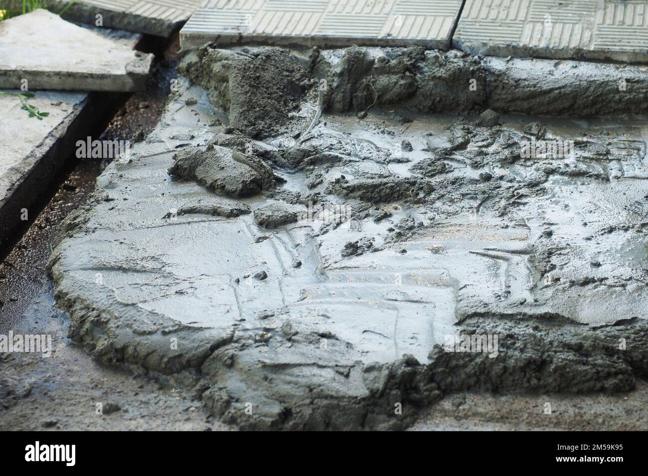 Primo piano di cemento liquido. Piastrella per pavimentazione. Sfondo della costruzione. Palo di mortaio per posare tegole.. Foto Stock