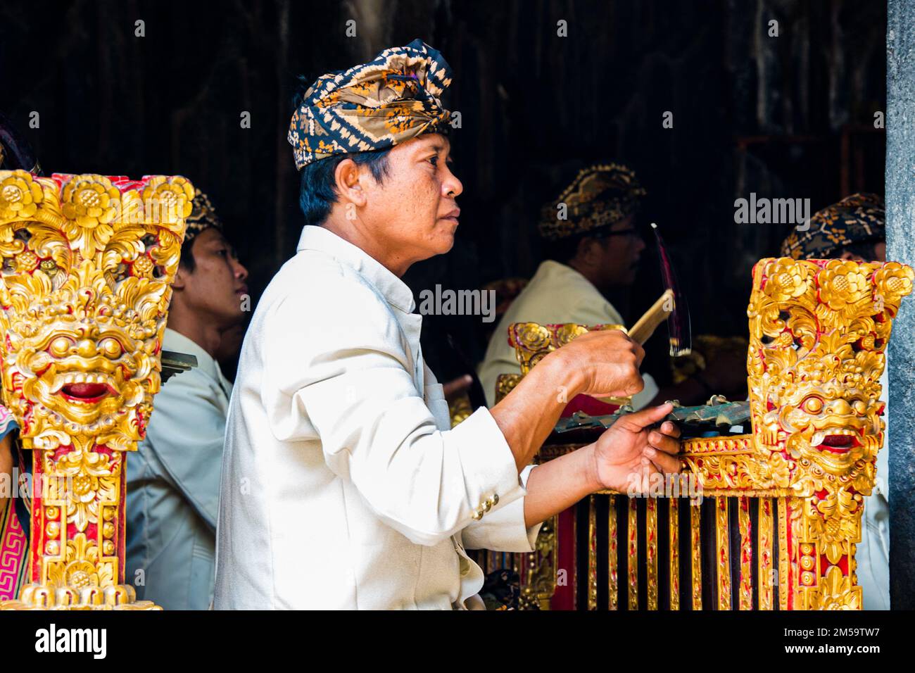 Bali - Indonesia - 10.22.2015: Musicista indonesiano vestito con abiti tradizionali suonando il gamelan balinese con una faccia diritta Foto Stock