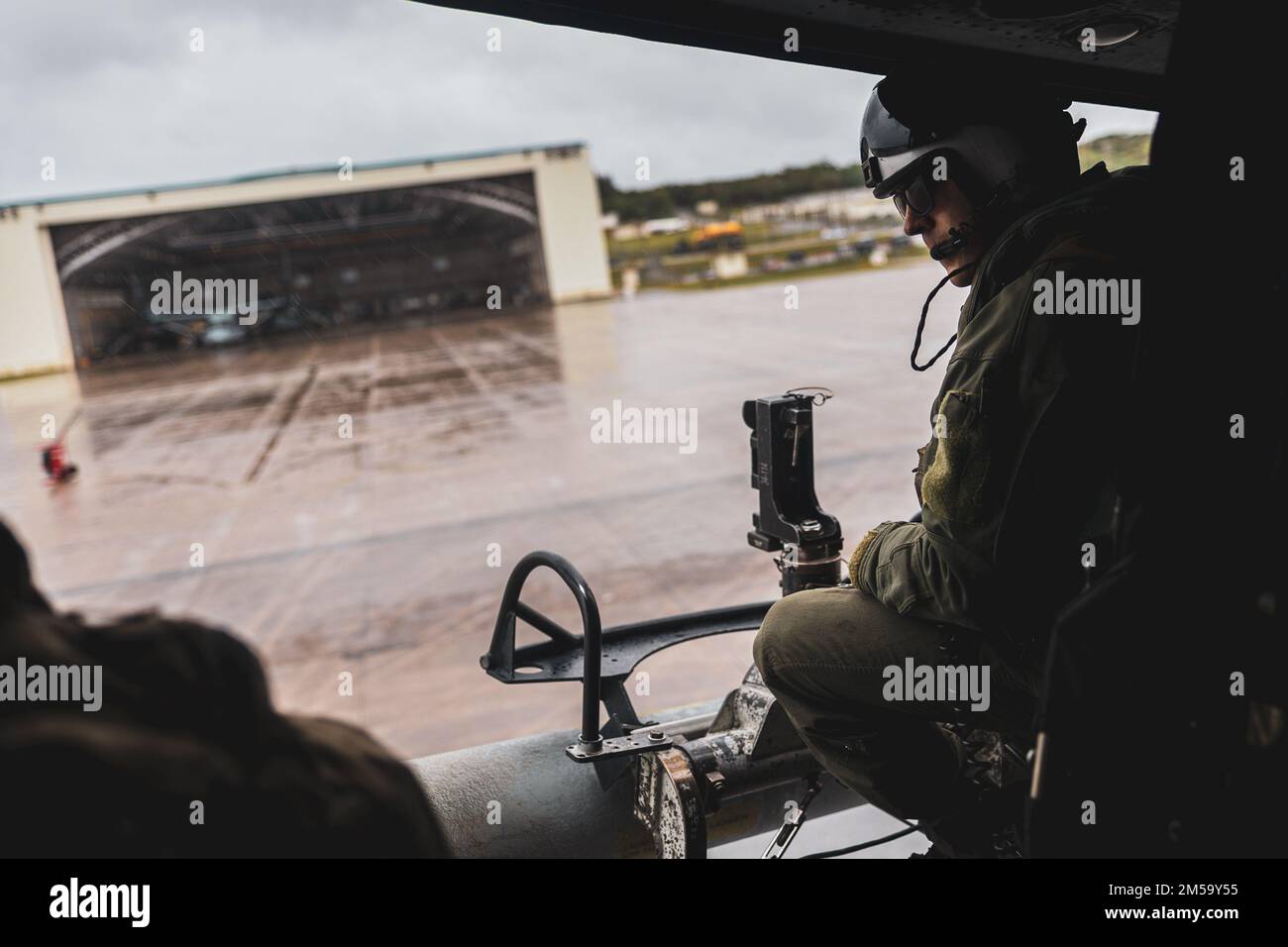 NEGLI STATI UNITI Marine with Marine Light Attack Helicopter Squadron (HMLA) 369, scansiona la linea di volo mentre decollava in un elicottero UH-1Y Venom a sostegno dell'esercizio 22 di Jungle Warfare sulla Stazione aerea del corpo Marino Futenma, Okinawa, Giappone, 14 febbraio 2022. JWX 22 è un'esercitazione di formazione sul campo su larga scala incentrata sull'utilizzo delle capacità integrate di partner congiunti e alleati per rafforzare la consapevolezza, le manovre e gli incendi in tutti i settori in un ambiente marittimo distribuito. Foto Stock