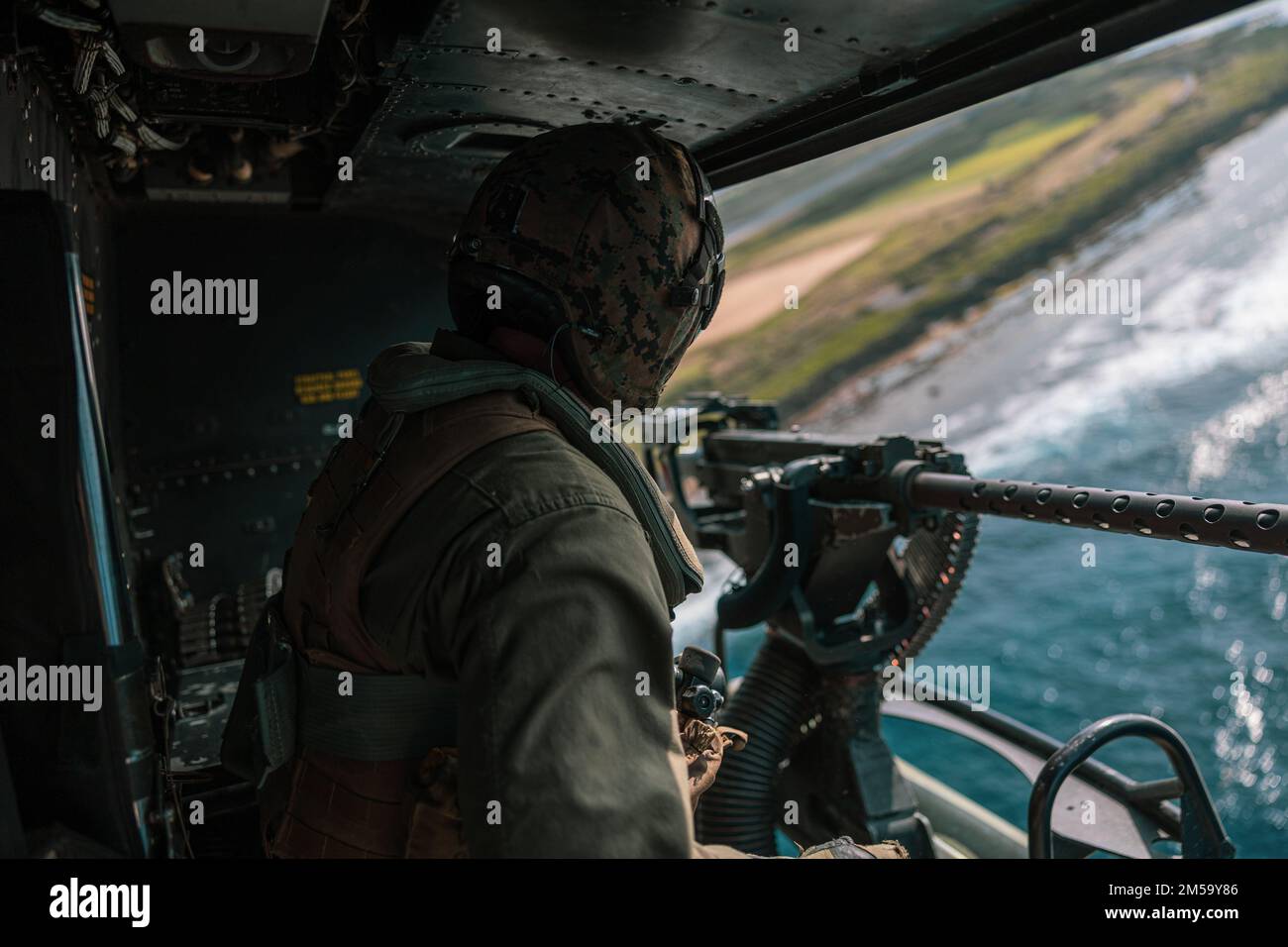 STATI UNITI Marines with Marine Light Attack Helicopter Squadron (HMLA) 369 scansiona l'orizzonte in un elicottero UH-1Y Venom durante un evento di addestramento dal vivo a sostegno dell'esercizio 22 di Jungle Warfare sull'isola di Shima, Giappone, 15 febbraio 2022. JWX 22 è un'esercitazione di formazione sul campo su larga scala incentrata sull'utilizzo delle capacità integrate di partner congiunti e alleati per rafforzare la consapevolezza, le manovre e gli incendi in tutti i settori in un ambiente marittimo distribuito. Foto Stock