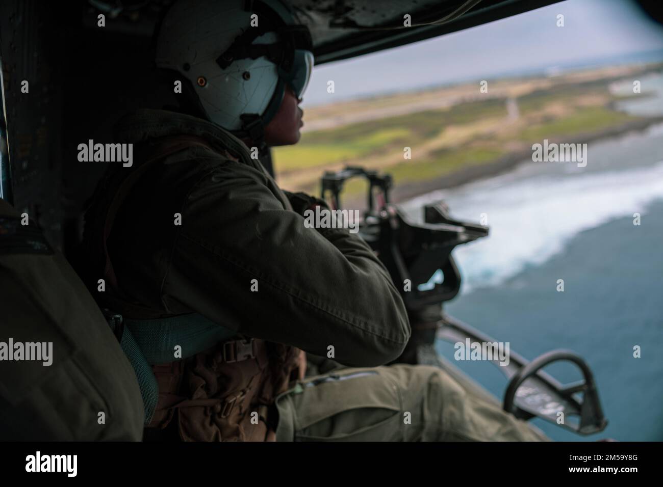 NEGLI STATI UNITI Marine with Marine Light Attack Helicopter Squadron (HMLA) 369 scansiona l'orizzonte in un elicottero UH-1Y Venom durante un evento di allenamento dal vivo a sostegno dell'esercizio 22 di Jungle Warfare sull'isola di Shima, Giappone, 15 febbraio 2022. JWX 22 è un'esercitazione di formazione sul campo su larga scala incentrata sull'utilizzo delle capacità integrate di partner congiunti e alleati per rafforzare la consapevolezza, le manovre e gli incendi in tutti i settori in un ambiente marittimo distribuito. Foto Stock