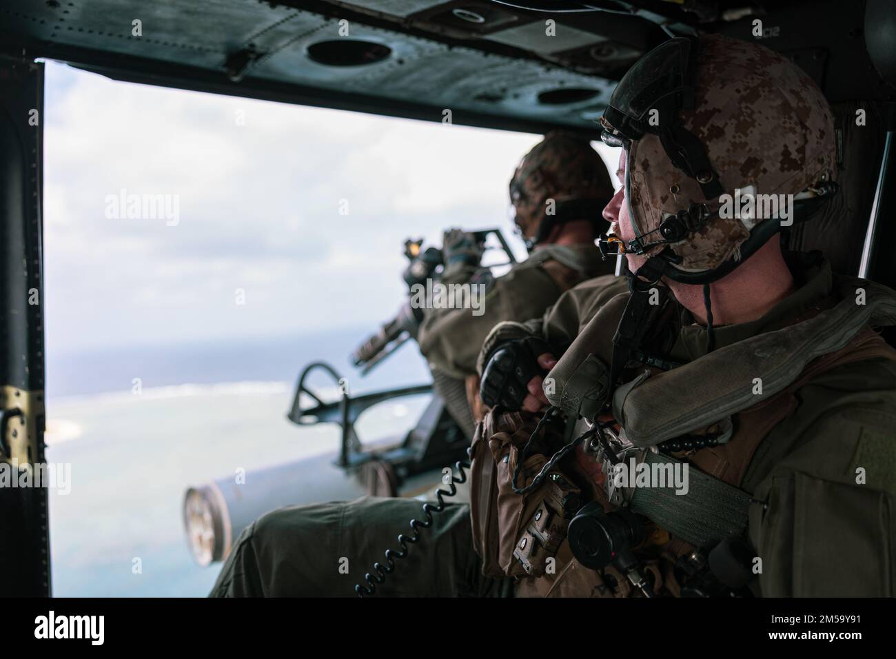 STATI UNITI Marines with Marine Light Attack Helicopter Squadron (HMLA) 369 scansiona l'orizzonte in un elicottero UH-1Y Venom durante un evento di addestramento dal vivo a sostegno dell'esercizio 22 di Jungle Warfare sull'isola di Shima, Giappone, 15 febbraio 2022. JWX 22 è un'esercitazione di formazione sul campo su larga scala incentrata sull'utilizzo delle capacità integrate di partner congiunti e alleati per rafforzare la consapevolezza, le manovre e gli incendi in tutti i settori in un ambiente marittimo distribuito. Foto Stock