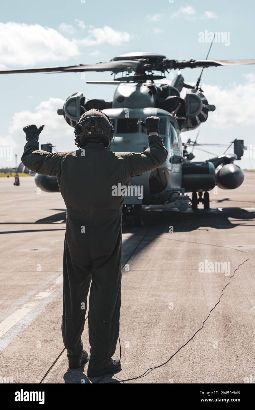 STATI UNITI Chad Jones, un capo dell'equipaggio di Super Stallion CH-53E assegnato a Marine Heavy Helicopter Squadron (HMH) 466, dà segnali di mano e braccio a un Super Stallion Helicopter CH-53E prima di decollare alla Marine Corps Air Station Futenma, Okinawa, Giappone, 1 marzo 2022. HMH-466 ha ospitato un volo VIP per il maggiore Gen. Brian Cavanaugh per soddisfare le ore di volo annuali e per mantenere la sua preparazione alla spedizione. Foto Stock