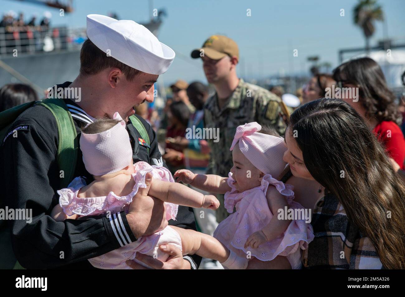 220214-N-US228-1005 SAN DIEGO (14 febbraio 2022) i marinai assegnati all'incrociatore missilistico guidato di classe Ticonderoga USS Lake Champlain (CG 57) abbracciano le loro famiglie dopo il ritorno al loro homeport alla base navale di San Diego. Lake Champlain, parte del Carl Vinson Carrier Strike Group, è tornato alla base navale di San Diego, 14 febbraio, a seguito di un dispiegamento nelle flotte degli Stati Uniti 3rd e 7th a sostegno della stabilità regionale e di un libero e aperto Indo-Pacifico. Foto Stock