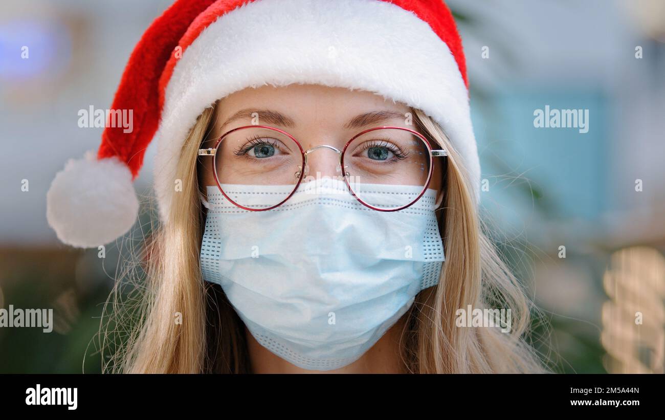 Primo piano femmina ritratto donna caucasica donna ragazza infermiera medico indossare rosso Santa Natale cappello cappello e occhiali e maschera protettiva medico nuovo Foto Stock