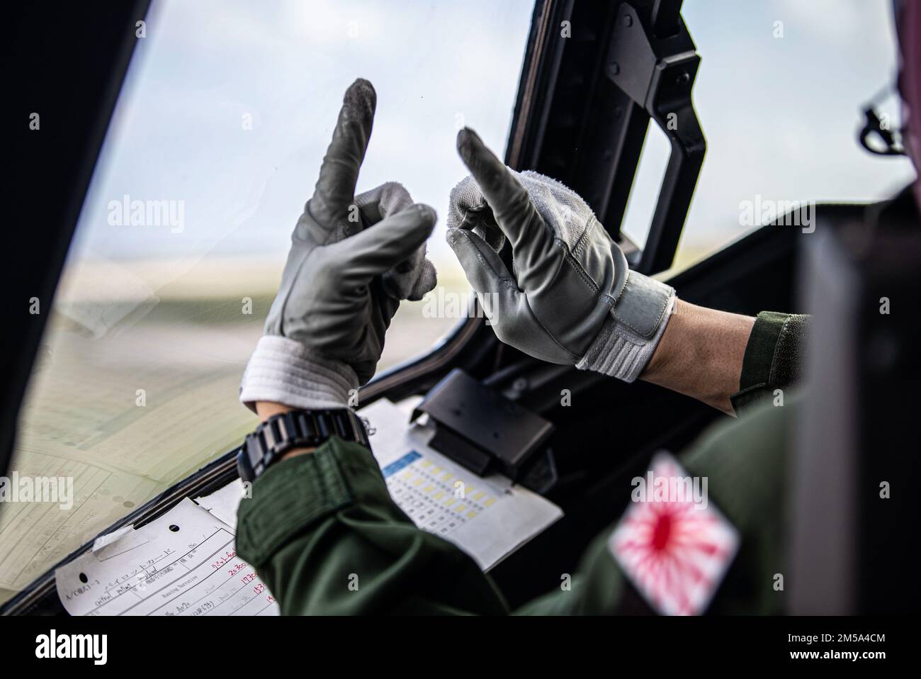 Il luogotenente Yuki Higashi, un pilota con lo Squadrone di salvataggio aereo 71st, segnala ad un maresciallo durante l'esercitazione Cope North 22 alla base dell'aeronautica di Andersen, Guam, 14 febbraio 2022. Cope North migliora le relazioni degli Stati Uniti con i nostri alleati e partner regionali promuovendo lo scambio di informazioni e perfezionando tattiche, tecniche e procedure condivise per integrare meglio le capacità di difesa multilaterale e migliorare l'interoperabilità a sostegno della sicurezza regionale. Foto Stock