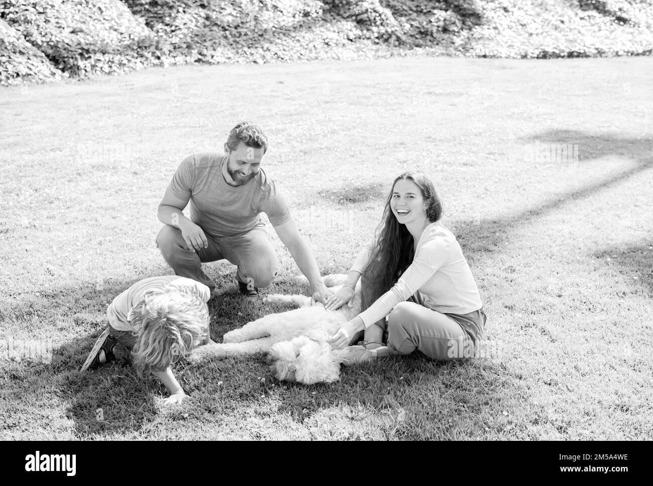 adozione e carità. giornata di famiglia. amicizia. padre madre e bambino su erba verde del parco. Foto Stock
