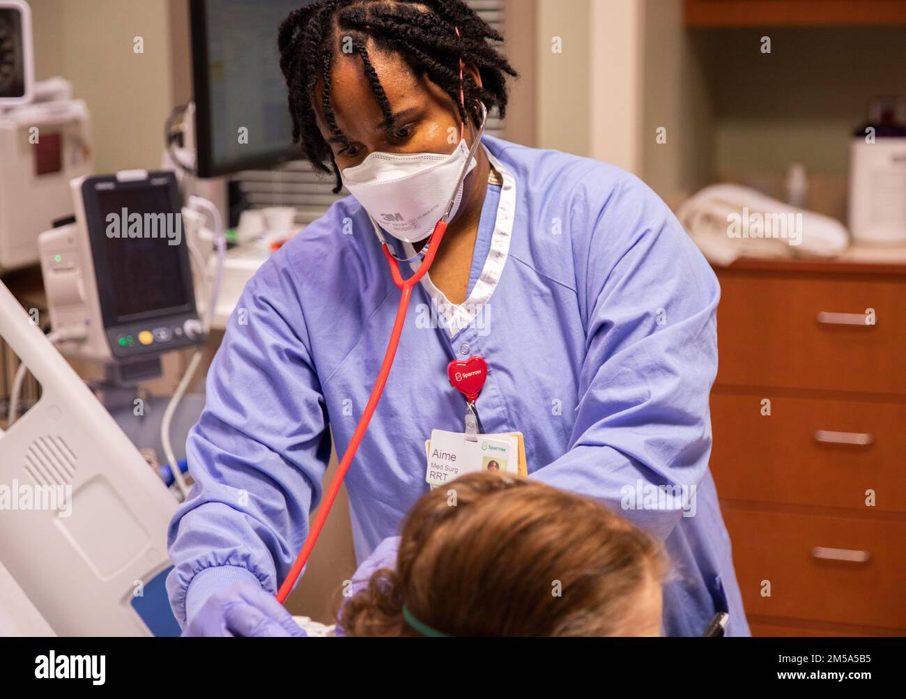 LANSING, Michigan. -- STATI UNITI Aime Brumant, un terapista respiratorio del team medico militare assegnato al Benning Martin Army Community Hospital di Fort Benning, Georgia, controlla un paziente presso lo Sparrow Hospital di Lansing, Michigan, 15 febbraio 2022. STATI UNITI Northern Command, attraverso gli Stati Uniti Army North, rimane impegnata a fornire un supporto flessibile al Dipartimento della Difesa per l'intera risposta COVID del governo. Foto Stock