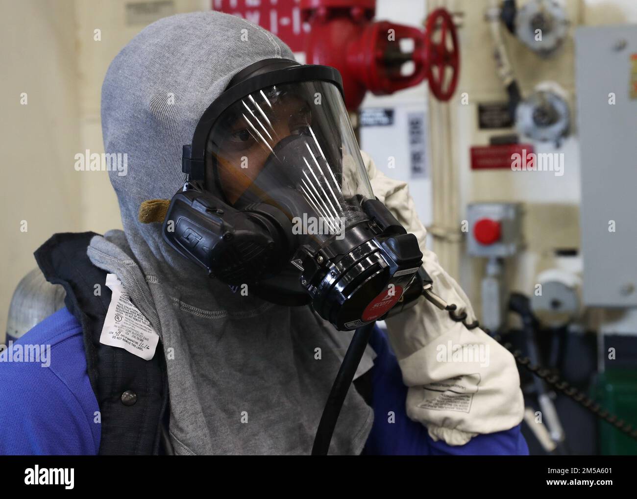 220214-N-TT639-1125 OCEANO PACIFICO (14 febbraio 2022) – Airman Daniel Palmer, di New York, gestisce un telefono a energia sonora durante un'esercitazione antincendio nell'hangar Bay a bordo di una nave d'assalto anfibia USS Tripoli (LHA 7), 14 febbraio. Tripoli sta conducendo operazioni di routine nella U.S. 3rd Fleet. Foto Stock