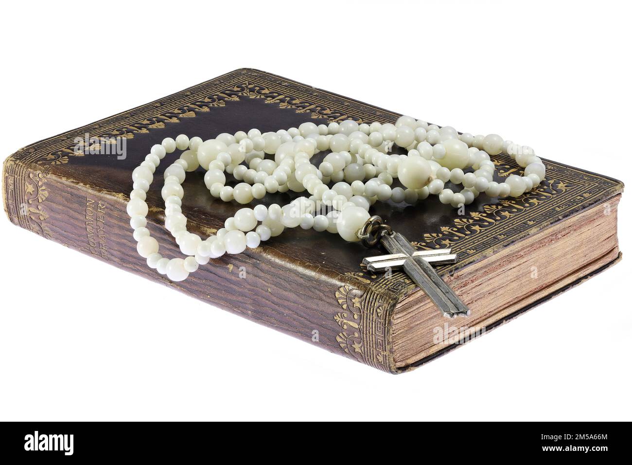 rosario su libro di preghiera comune vintage isolato su sfondo bianco Foto Stock