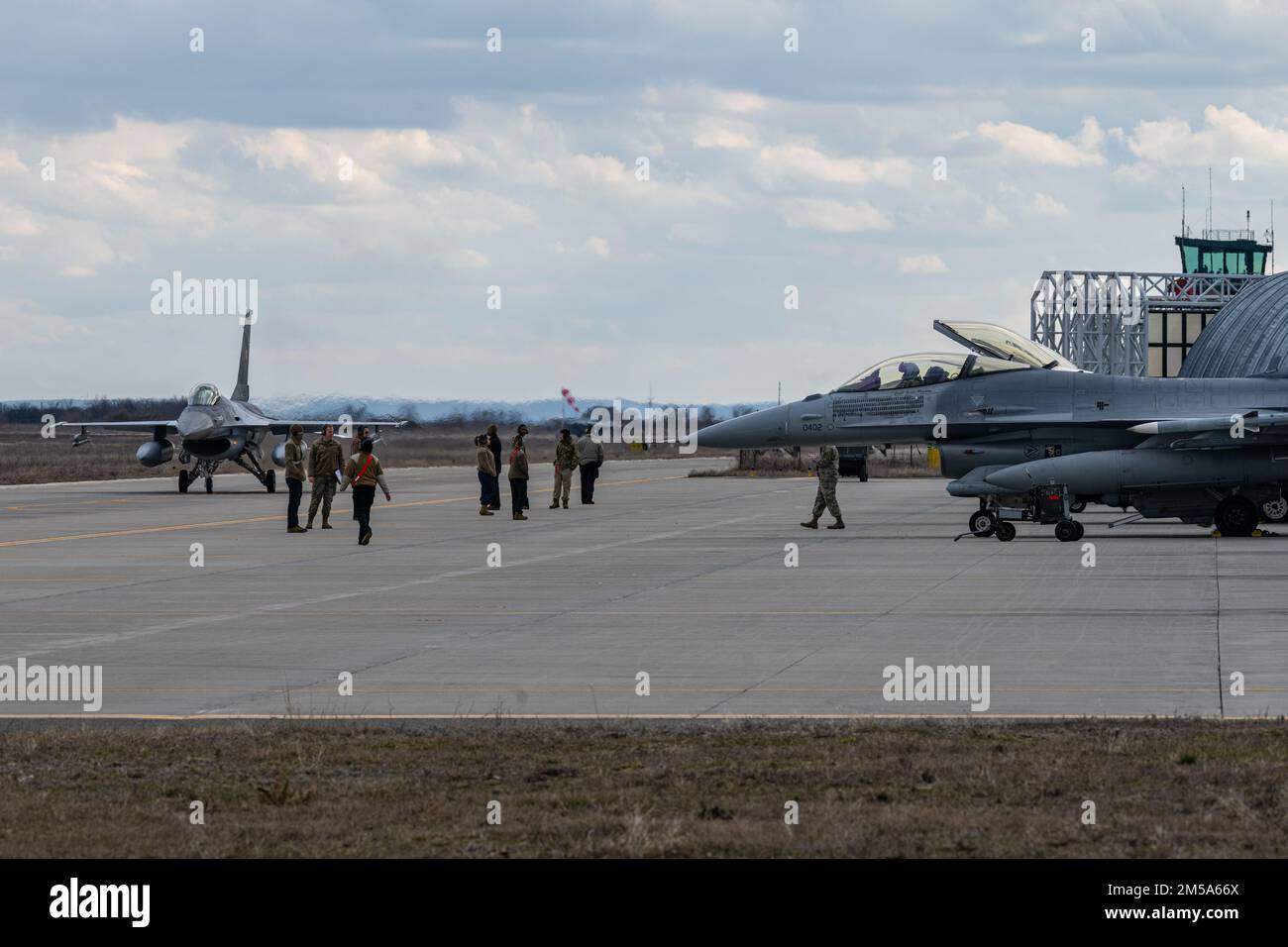 Una forza aerea rumena F-16 Fighting Falcon aerei taxi da manutentori e aerei assegnati alla 52nd Fighter Wing alla base aerea di Spangdahlem, Germania, sulla base aerea di Fetesti, Romania, 14 febbraio 2022. Rumeno e USA Le forze aeree F-16s condurranno operazioni di formazione congiunte per una maggiore vigilanza e deterrenza all'interno del teatro europeo. Foto Stock