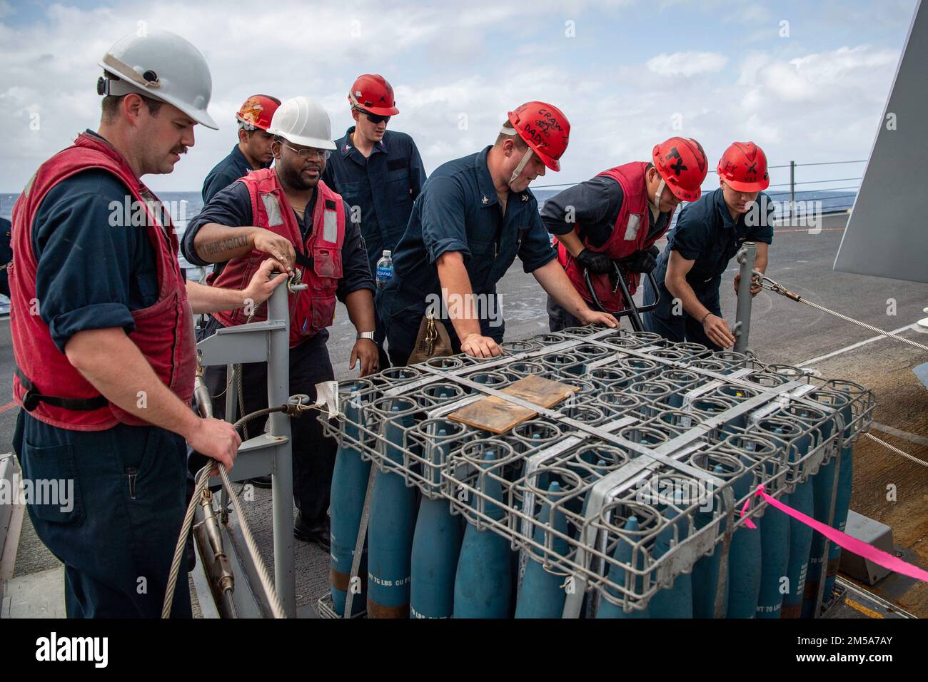 SOUTH CHINA SEA (15 febbraio 2022) marinai assegnati alla Combat Gunnery Division a bordo del cacciatorpediniere missilistico guidato di classe Arleigh Burke USS Dewey (DDG 105) stow munizioni per la pistola calibro Mark 45 – 5 pollici durante un rifornimento in mare con la nave militare Sealift Command cargo secco e munizioni USNS Alan Shepard (T-AKE 3). Dewey è assegnato a Destroyer Squadron (DESRON) 15 e sta supportando un Indo-Pacific libero e aperto. CTF 71/DESRON 15 è la più grande DESRON della Marina e la principale forza di superficie della flotta statunitense 7th. Foto Stock