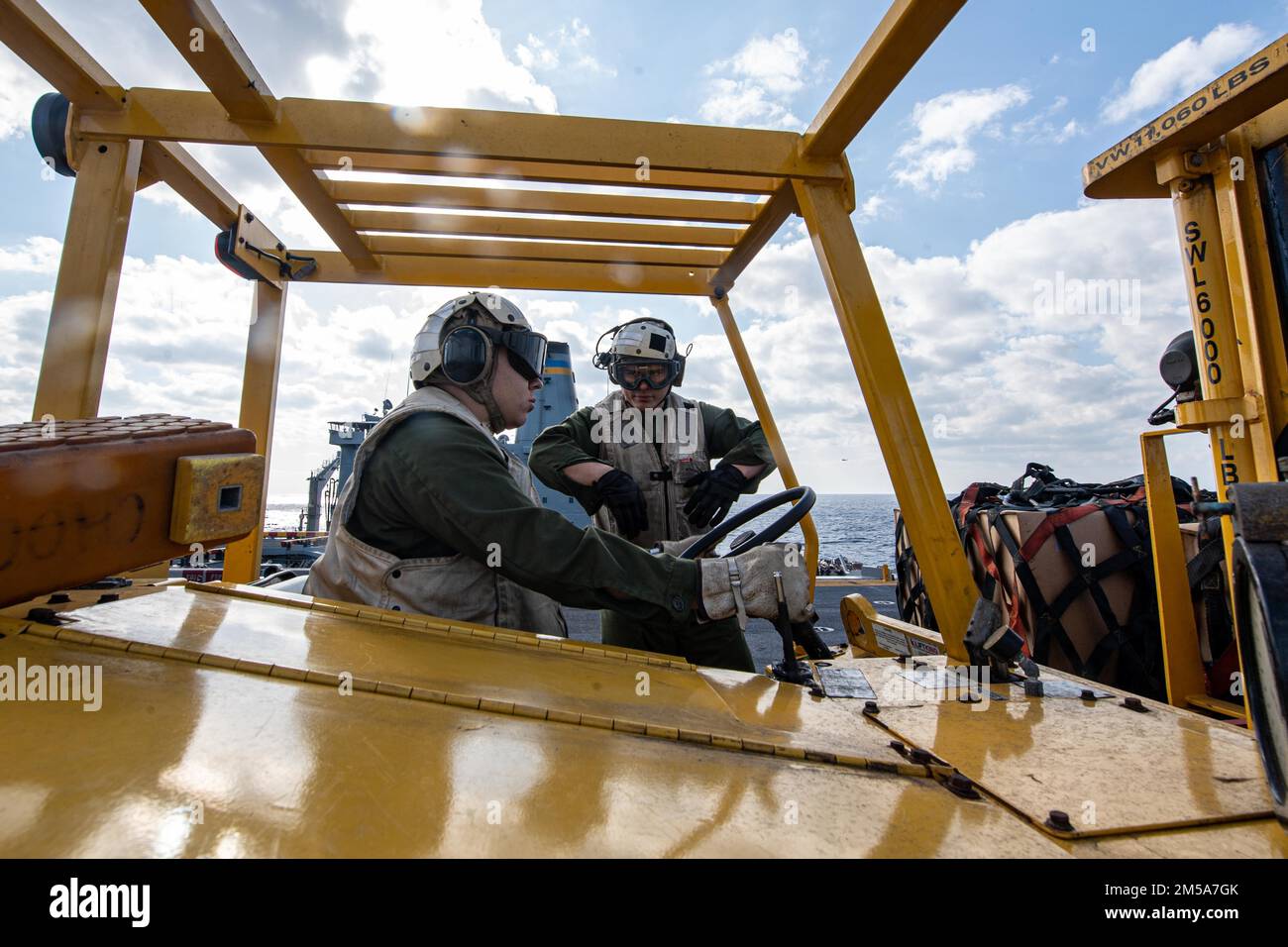 MARE DELLE FILIPPINE (15 febbraio 2022) lancia CPL. Tristan Anderton, a sinistra, da Kaysville, Utah, Eric Martinez, di Oklahoma City, ha entrambi assegnato alla 31st Marine Expeditionary Unit (MEU), trasportando il carico sul ponte di volo della nave d'assalto anfibia USS America (LHA 6) dispiegata in avanti durante un rifornimento verticale con l'oliatore di rifornimento della flotta USNS Yukon (T-AO 202). L'America, nave guida dell'America Amphibious Ready Group, insieme al 31st MEU, opera nell'area di responsabilità della flotta degli Stati Uniti 7th per migliorare l'interoperabilità con alleati e partner e fungere da r Foto Stock