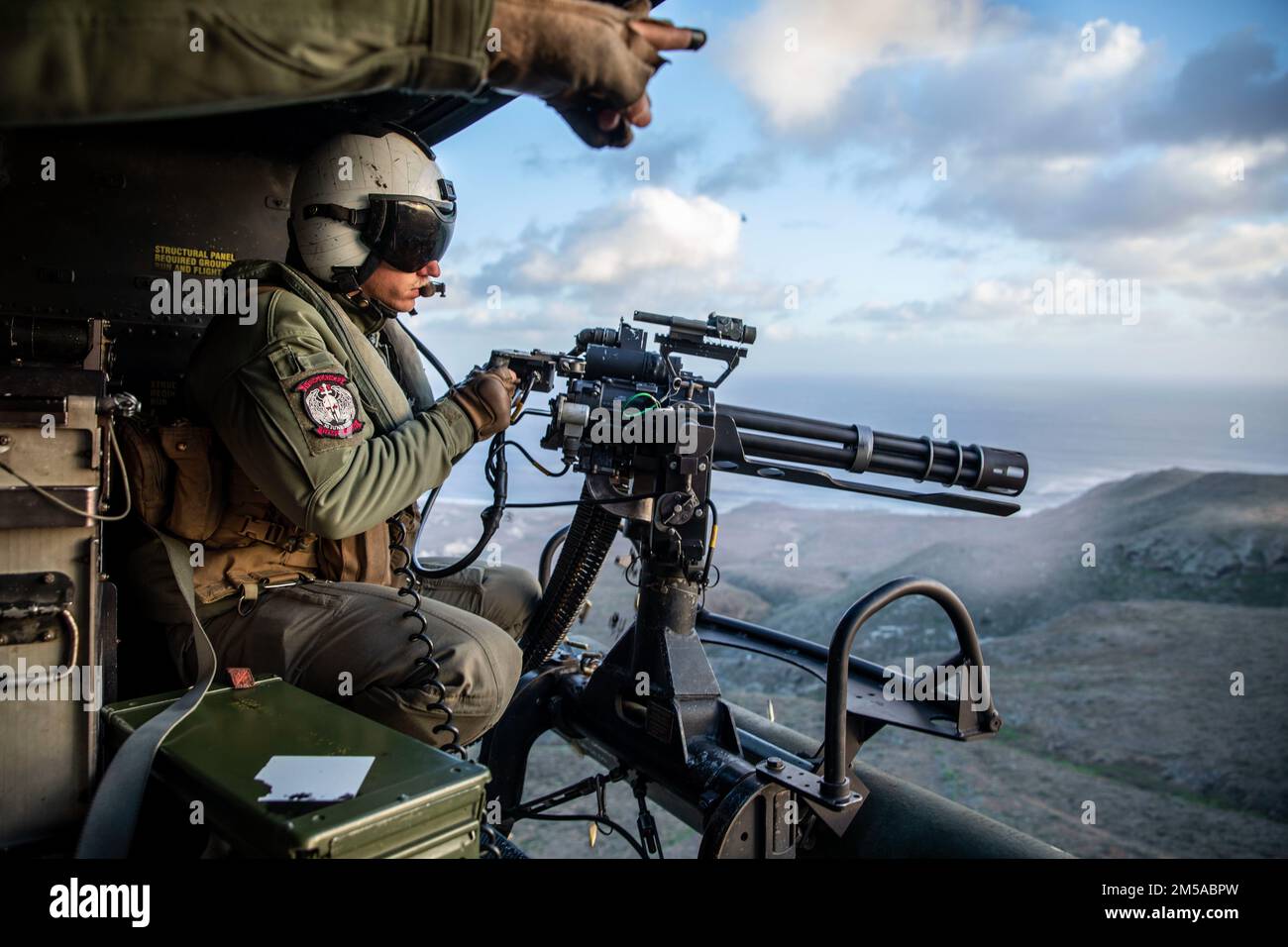 STATI UNITI Wyatt Stark, un capo dell'equipaggio assegnato a Marine Attack Light Attack Helicopter Squadron 469, Marine Aircraft Group 39, 3rd Marine Aircraft Wing (MAW), spara un minigun GAU-17 durante una gamma di fuoco live su una UH-1Y Venom a San Clemente Island, California, 15 febbraio 2022. Winter Fury 22 offre ai Marines di 3rd MAW opportunità di formazione realistiche e pertinenti necessarie per rispondere a qualsiasi crisi in tutto il mondo e vincere in modo decisivo in un conflitto marittimo altamente contestato. Foto Stock