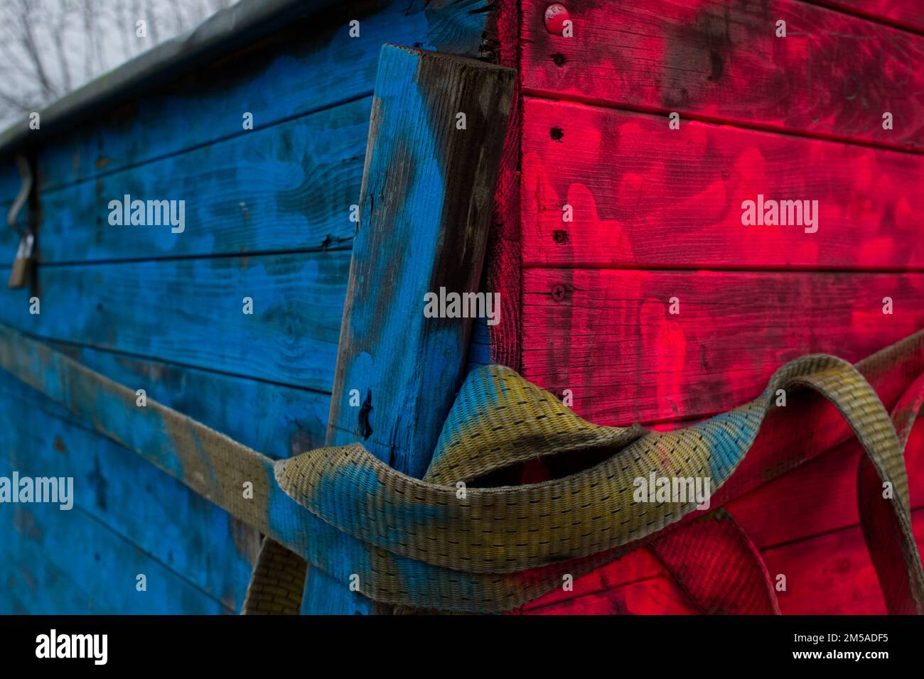 Grande cassa in legno con lati dipinti in colori luminosi di blu e rosso e cintura in tessuto beige Foto Stock