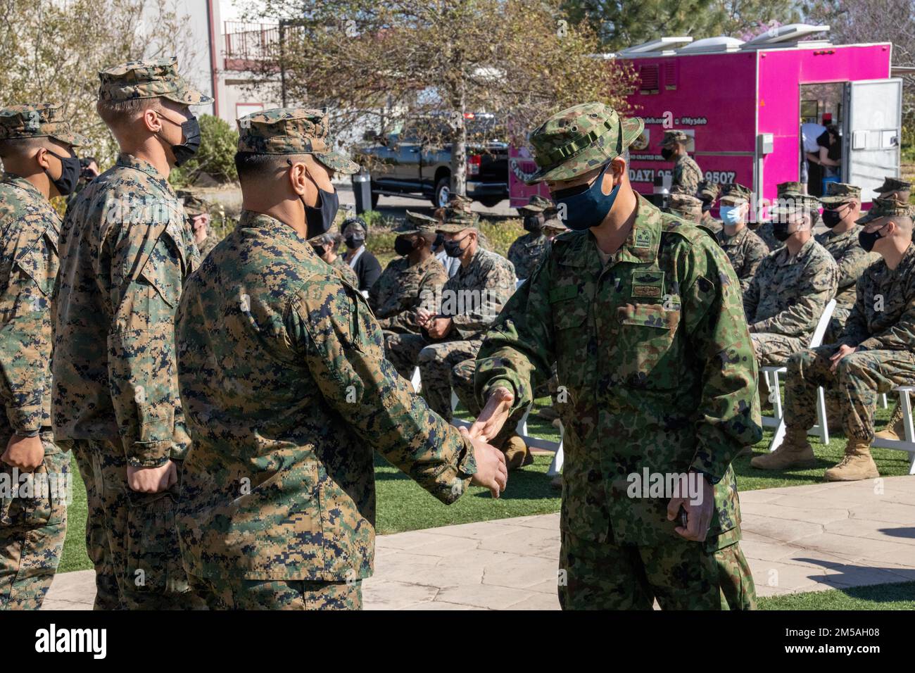 Kazuhiro Irie, ufficiale comandante del reggimento di Amphibious Rapid Deployment 2nd, si congratula con gli Stati Uniti e gli dà una moneta Marines per la loro prestazione superiore durante l'esercitazione Iron Fist 2022 come parte della cerimonia di chiusura alla base del corpo dei Marine Camp Pendleton, California, 16 febbraio 2022. Per quasi due decenni gli Stati Uniti Marine Corps, Stati Uniti Navy, e JGSDF hanno condotto l'esercitazione Iron Fist, addestrandosi insieme nelle operazioni anfibie e affermando l'impegno degli Stati Uniti ai nostri alleati. Foto Stock