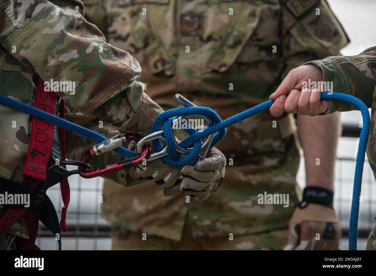 Un vigile del fuoco 48th Fighter Wing si allaccia alla loro linea durante l'allenamento a Rappel presso Royal Air Force Lakenheath, Inghilterra, 16 febbraio 2022. L'addestramento del rappel consente ai vigili del fuoco di familiarizzare con le operazioni di salvataggio ad angolo alto e basso in cui è pericoloso o impossibile raggiungere una vittima attraverso mezzi più convenzionali. Foto Stock