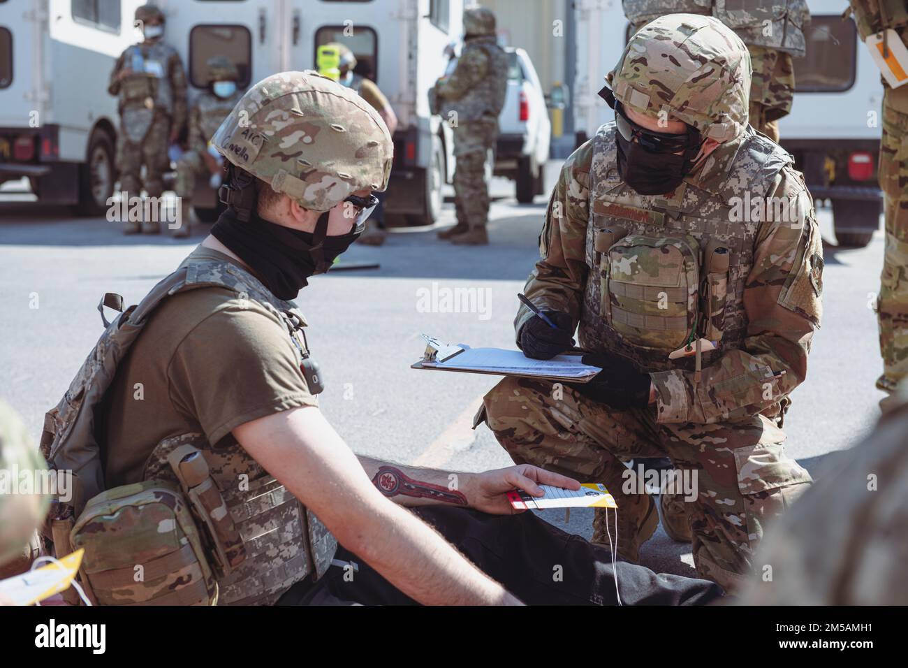 NEGLI STATI UNITI Air Force Airman assegnato al 379th Expeditionary Medical Group (a destra), parla con un paziente simulato alla base aerea di al Udeid, Qatar, 16 febbraio 2022. Varie unità intorno all'installazione hanno partecipato al Grand Shield 22-3, un addestramento di preparazione di quattro giorni che ha posto le minacce simulate quali i missili balistici del teatro (TBM) ed i sistemi aerei non presidiati (UAS). Foto Stock