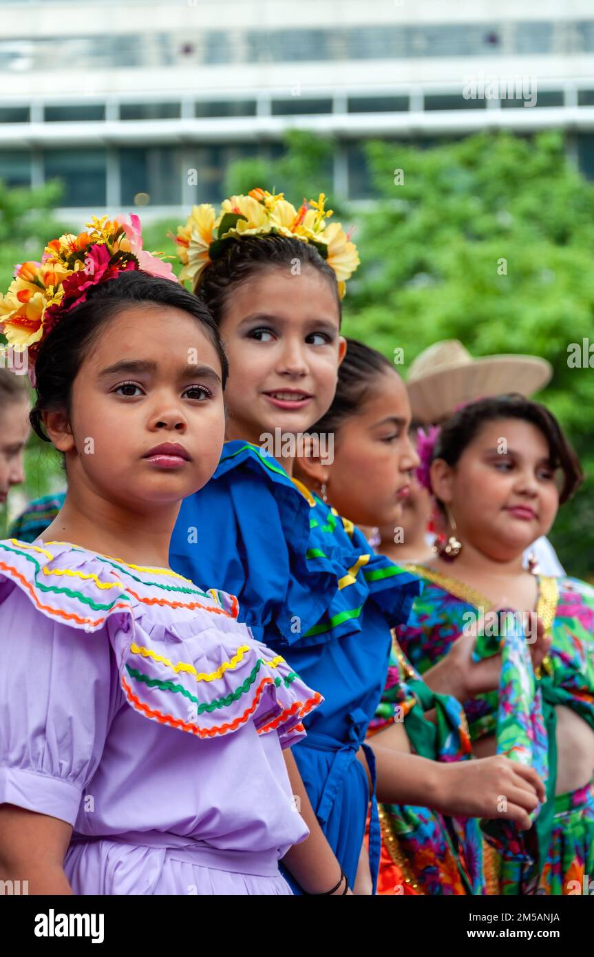 Un gruppo di bambini che indossano abiti tradizionali latinoamericani si trova sul palco. L'evento annuale si svolge in piazza Mel Lastman. Foto Stock