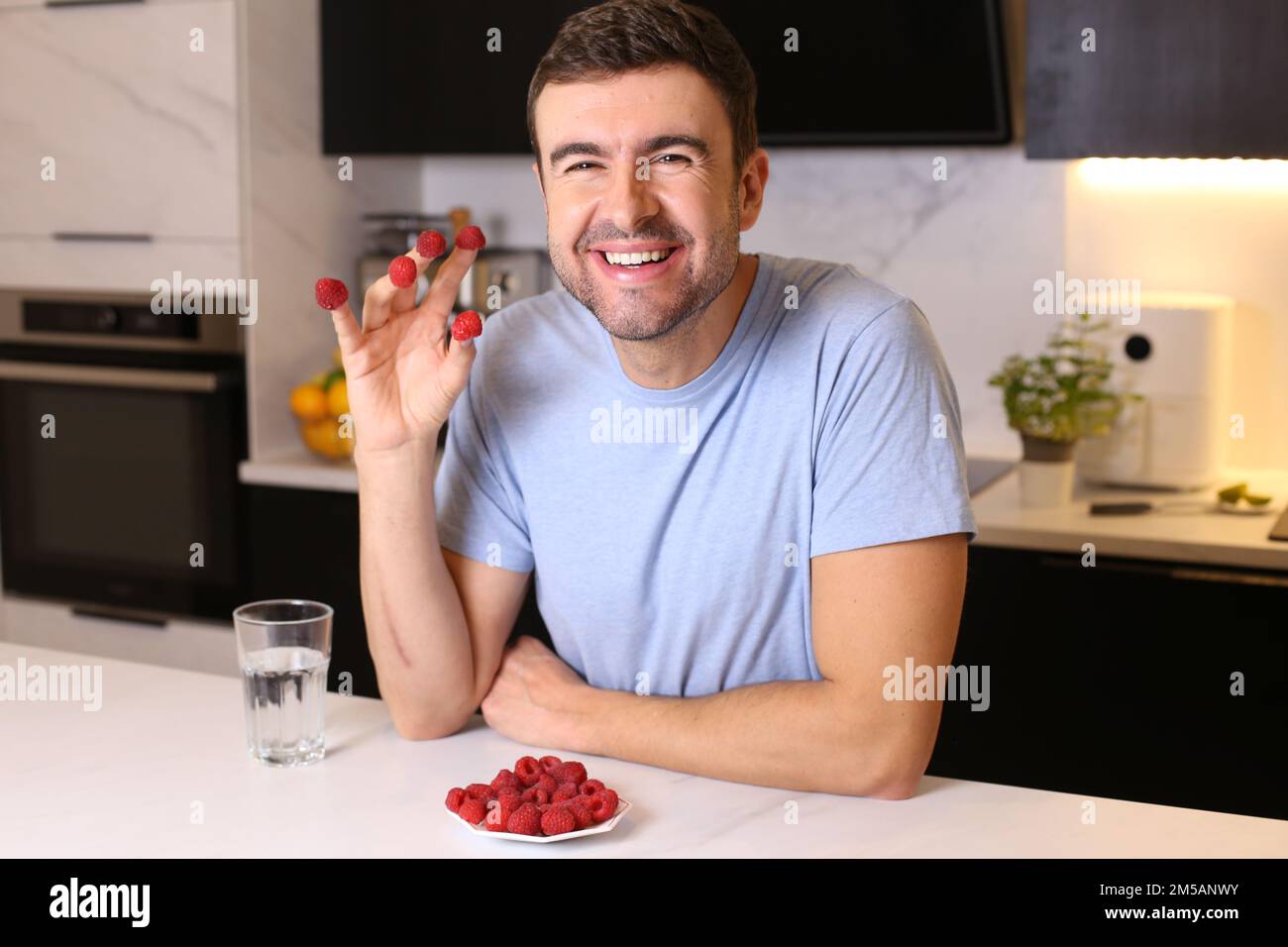 Uomo che gode di un piatto di framboise fresco Foto Stock