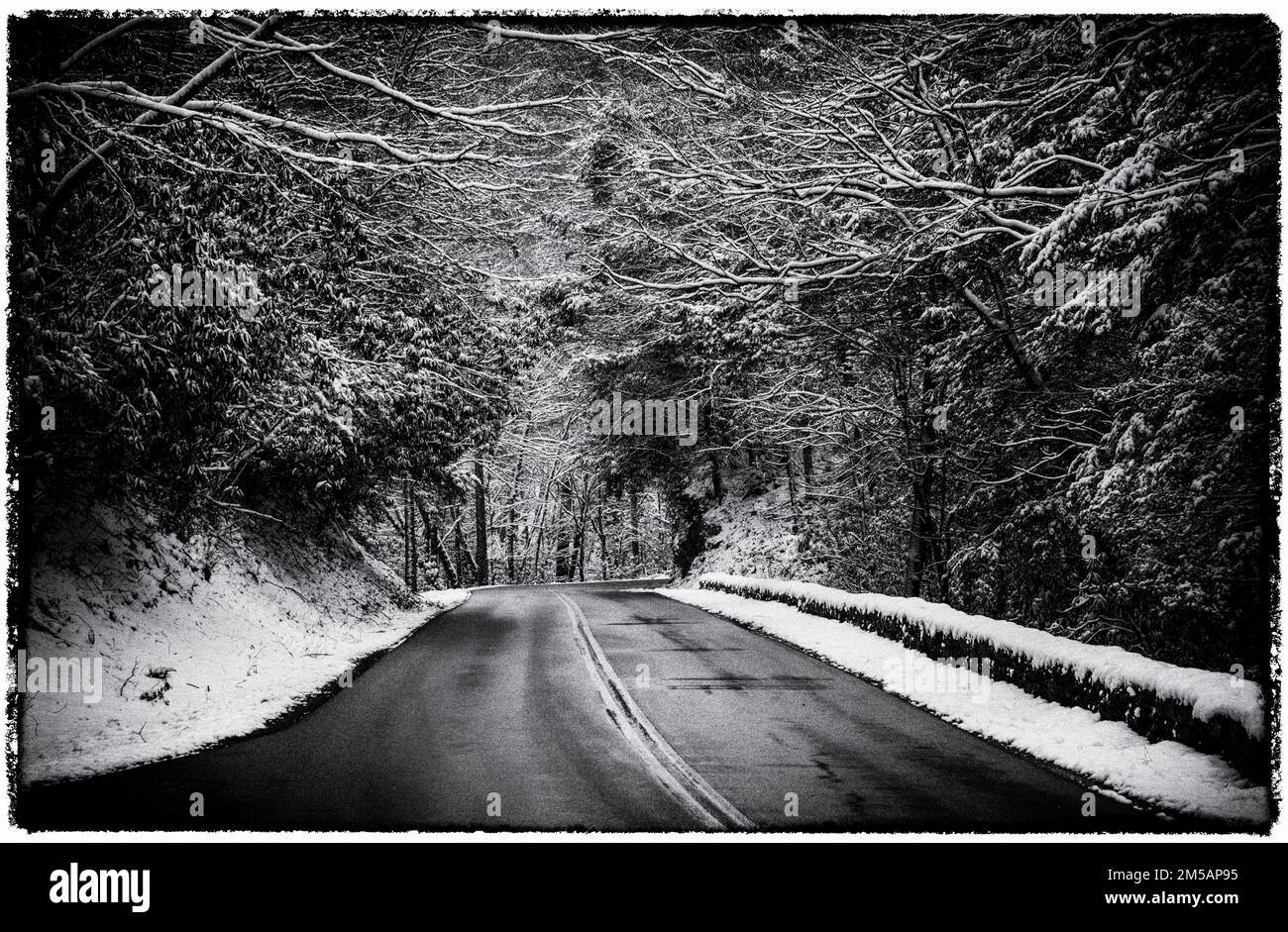 Una foto sgranata di una strada recentemente coperta da ghiaccio e neve, che rende le Smoky Mountains un luogo pericoloso dove guidare quel giorno. Foto Stock