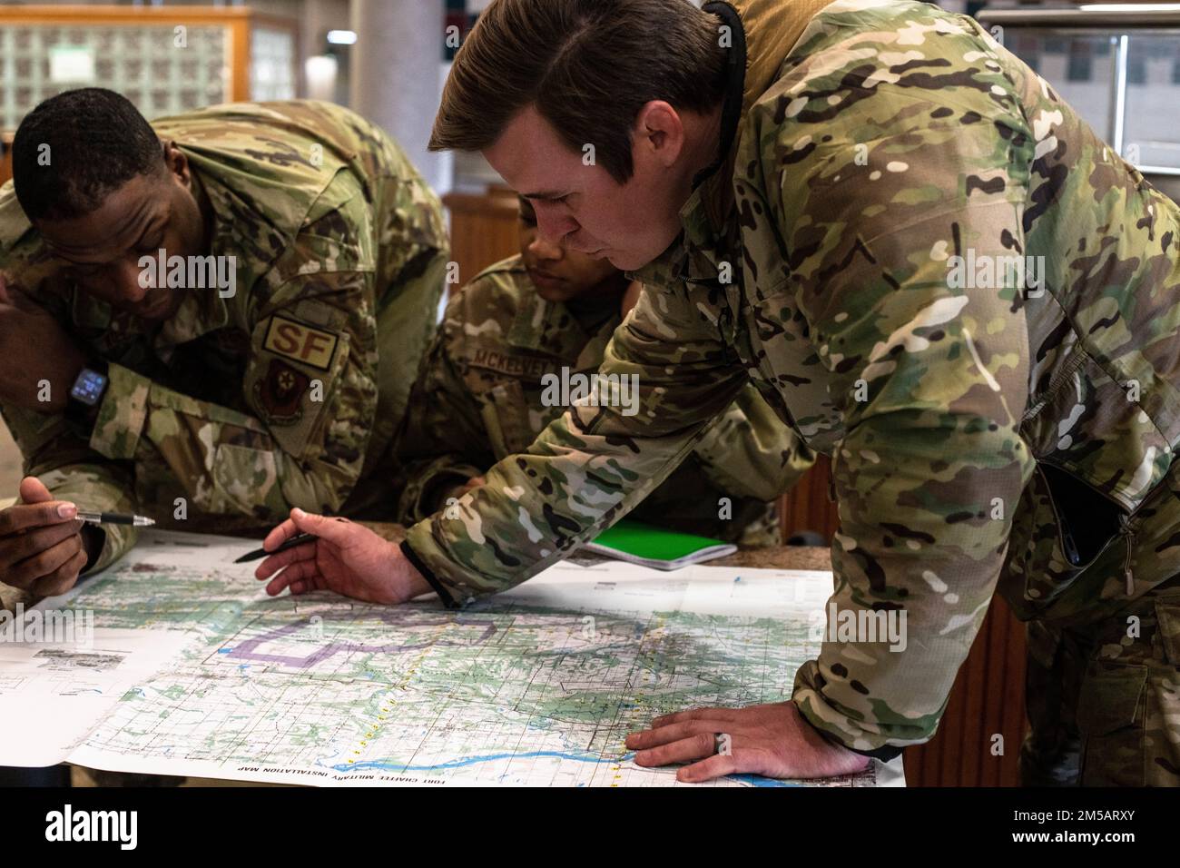 STATI UNITI Personale dell'aeronautica Sgt. Cade Draper, un responsabile del programma di qualificazione del controllore di attacco terminale congiunto con il volo di addestramento di combattimento 137th, la Guardia Nazionale dell'aria dell'Oklahoma aiuta gli studenti della squadra di sostegno della missione (MST) a tracciare punti su una mappa durante l'addestramento della MST presso la base della Guardia Nazionale dell'aria di Will Rogers, Oklahoma City, 8 febbraio 2022. Gli studenti hanno imparato una varietà di abilità di navigazione terrestre da applicare durante un esercizio sul campo più avanti nella settimana. Foto Stock STATI UNITI Personale dell'aeronautica Sgt. Cade Draper, un responsabile del programma di qualificazione del controllore di attacco terminale congiunto con il volo di addestramento di combattimento 137th, la Guardia Nazionale dell'aria dell'Oklahoma aiuta gli studenti della squadra di sostegno della missione (MST) a tracciare punti su una mappa durante l'addestramento della MST presso la base della Guardia Nazionale dell'aria di Will Rogers, Oklahoma City, 8 febbraio 2022. Gli studenti hanno imparato una varietà di abilità di navigazione terrestre da applicare durante un esercizio sul campo più avanti nella settimana. Foto Stock